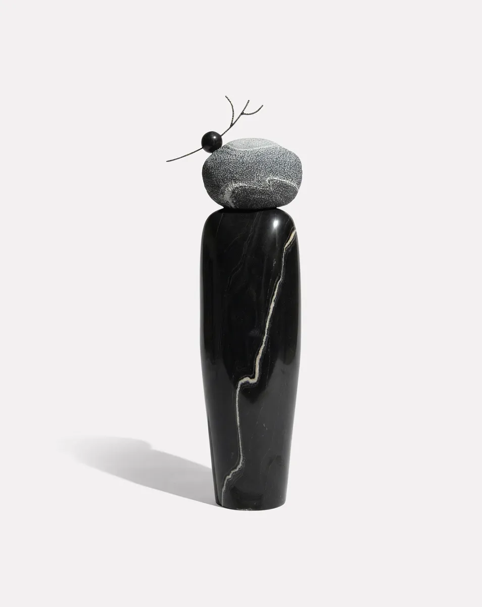 Curio's own product photo of the TARU sculpture: black marble topped with a stone, on white
